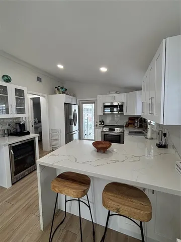 a kitchen with refrigerator and chairs