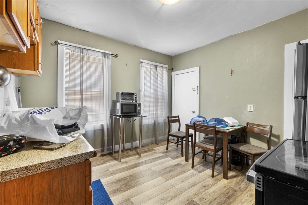 46 Theodore Street Boston, MA 02124 - Photo 15 of 24 a kitchen with a table chairs and a refrigerator