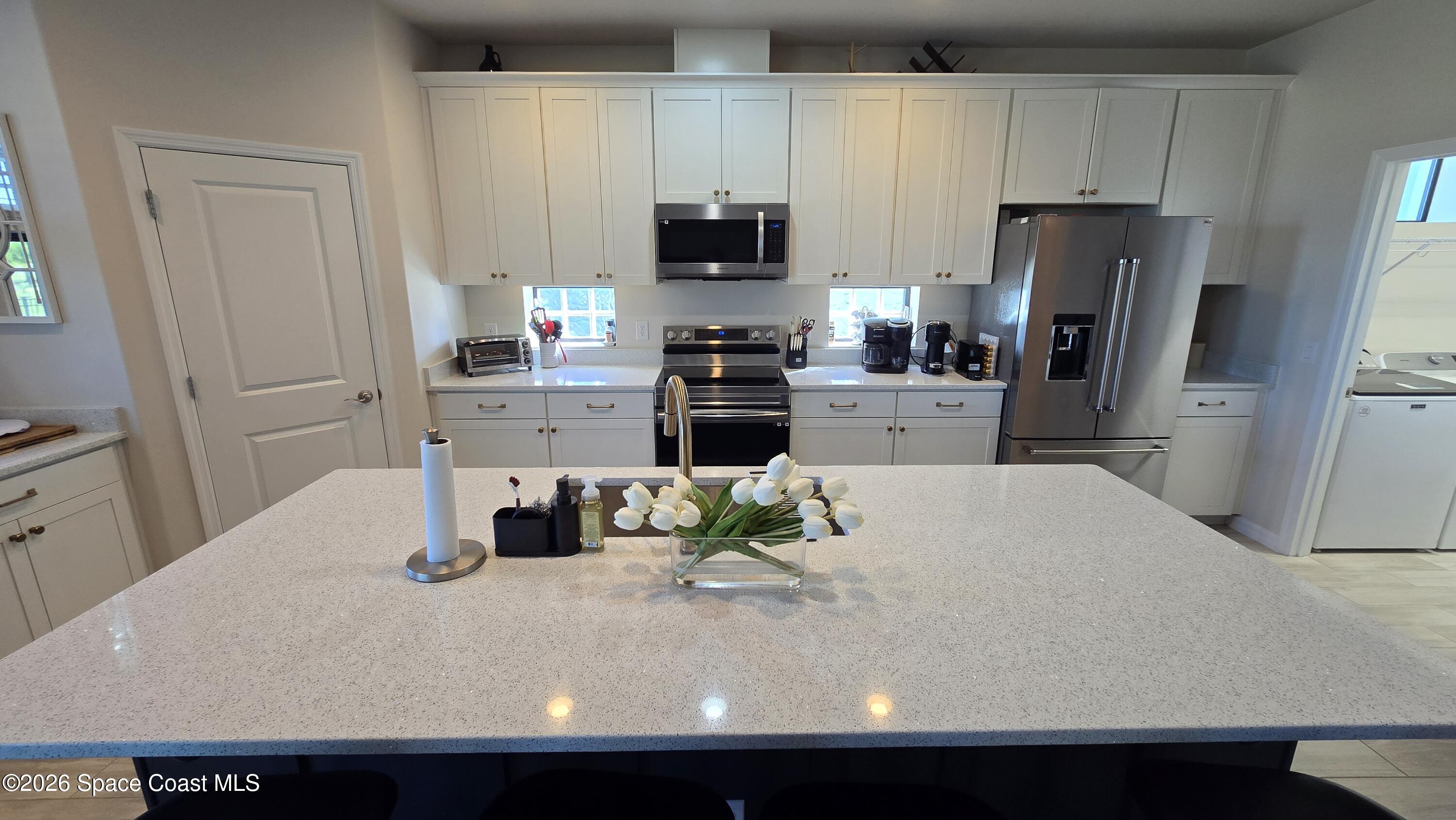 8137 Dobre Way Melbourne, FL 32940 - Photo 4 of 25 a kitchen with a refrigerator and a stove top oven