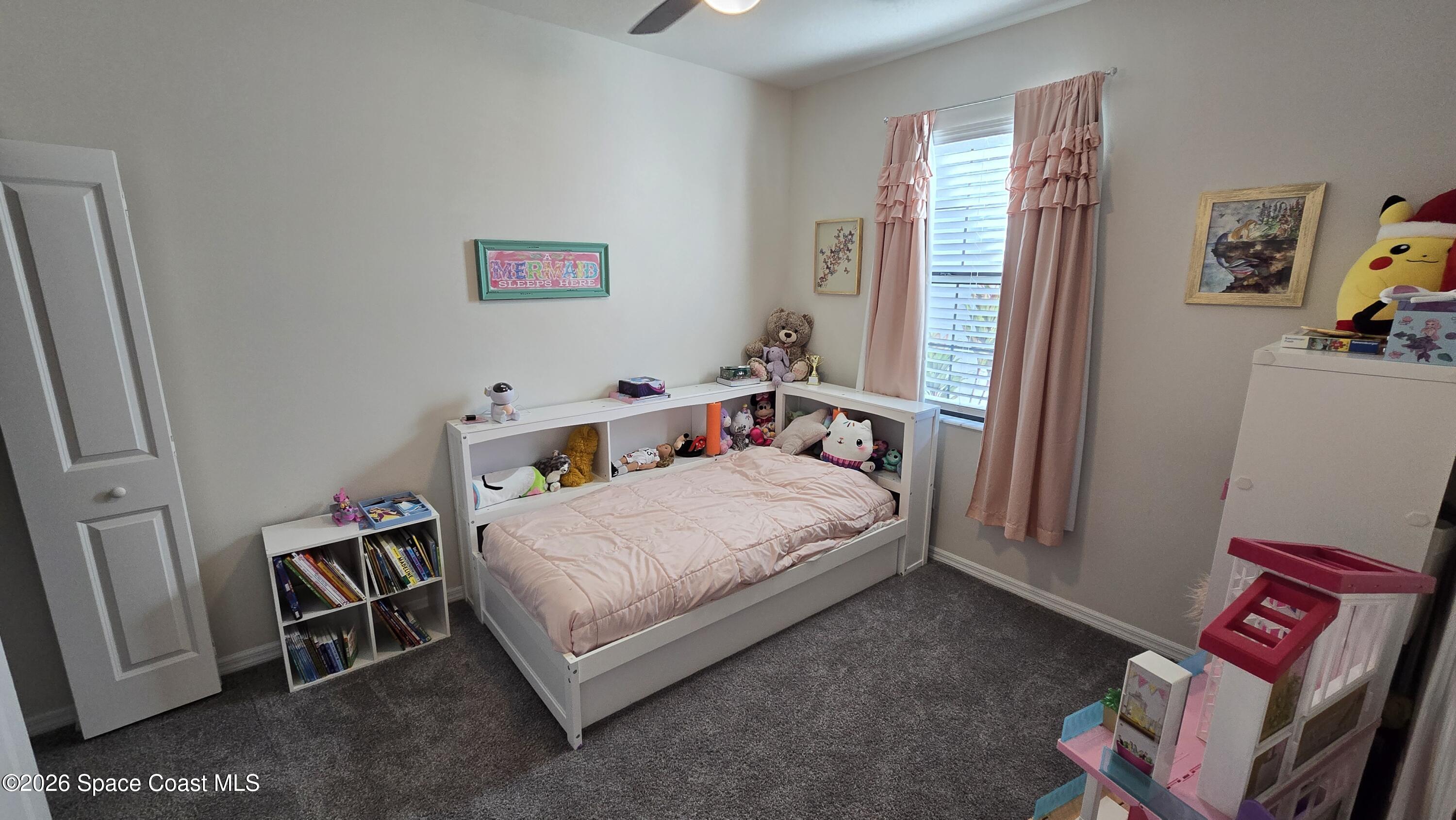 8137 Dobre Way Melbourne, FL 32940 - Photo 9 of 25 a bedroom with a bed and a window