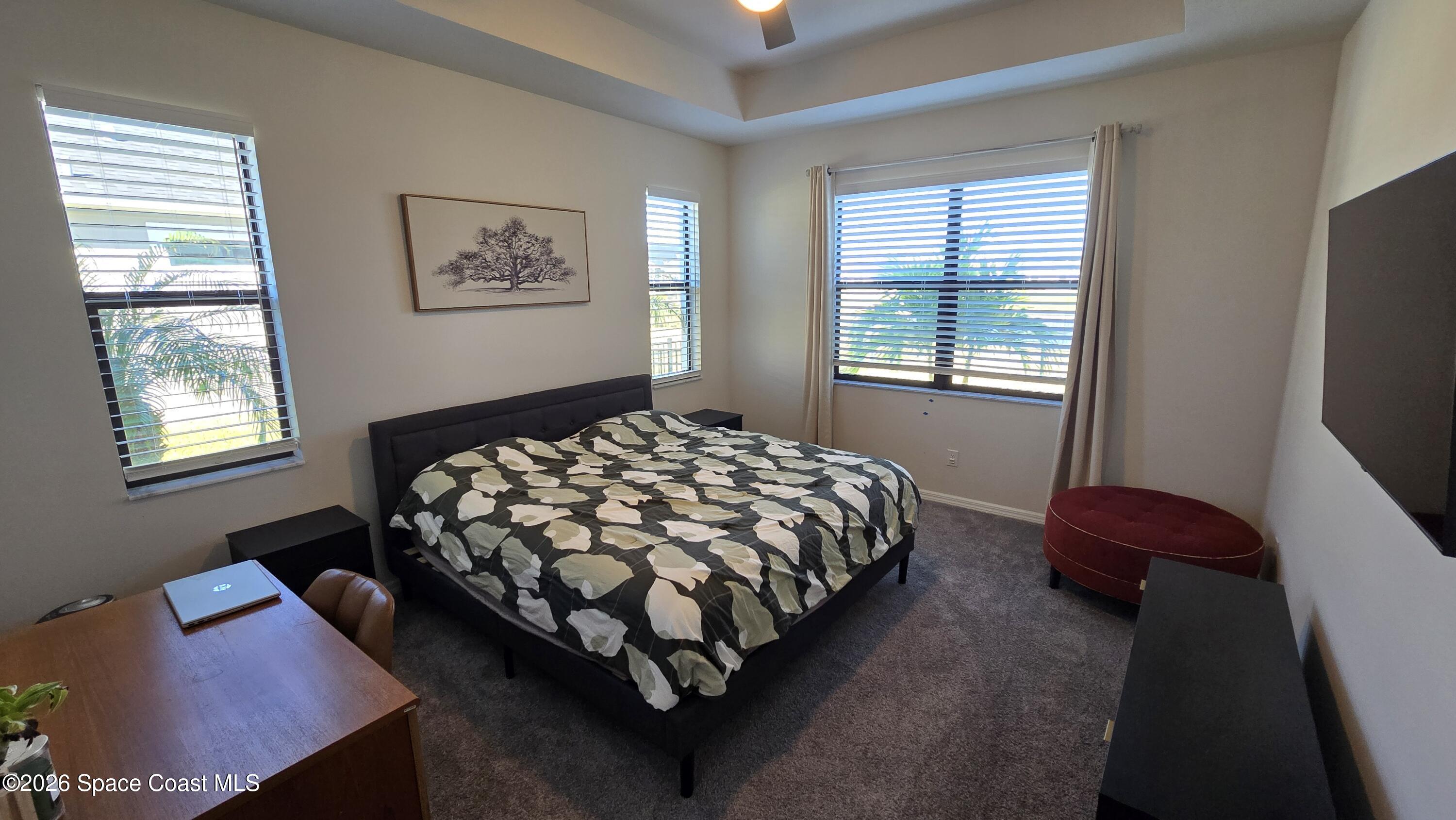 8137 Dobre Way Melbourne, FL 32940 - Photo 10 of 25 a bedroom with a bed lamp and a window