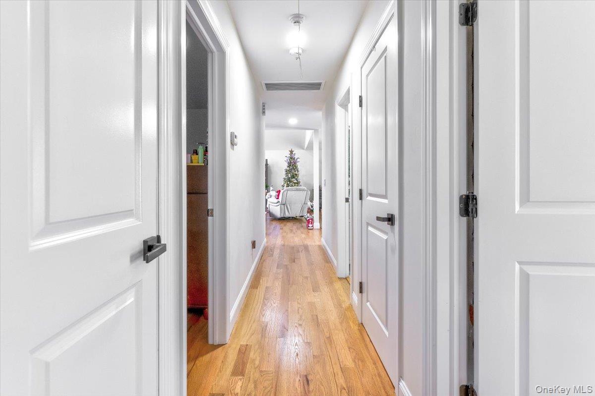 468 Granny Road Medford, NY 11763 - Photo 18 of 42 a view of a hallway with wooden floor and a bathroom