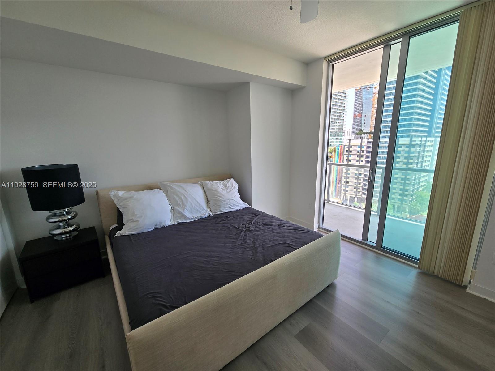79 Southwest 12th Street, Unit 1701S Miami, FL 33130 - Photo 12 of 25 a living room with a bed furniture and a window