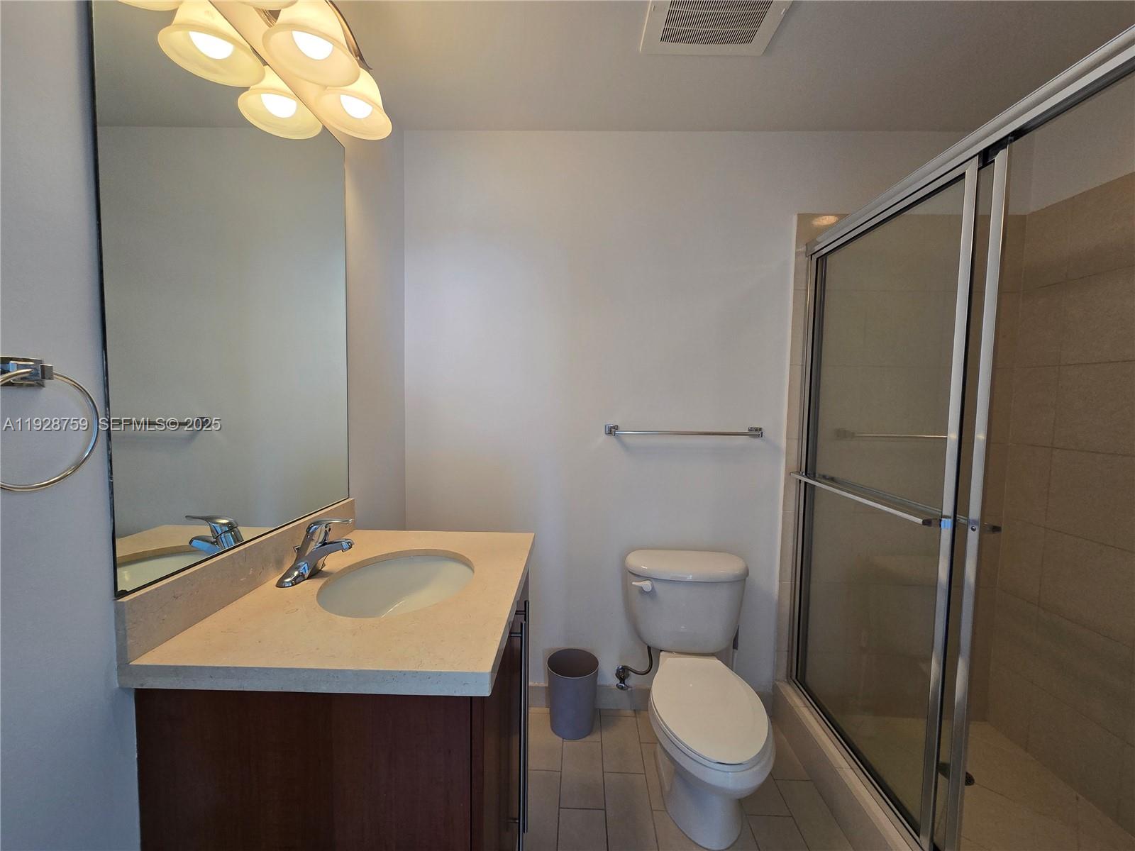 79 Southwest 12th Street, Unit 1701S Miami, FL 33130 - Photo 20 of 25 a bathroom with a toilet a sink and shower