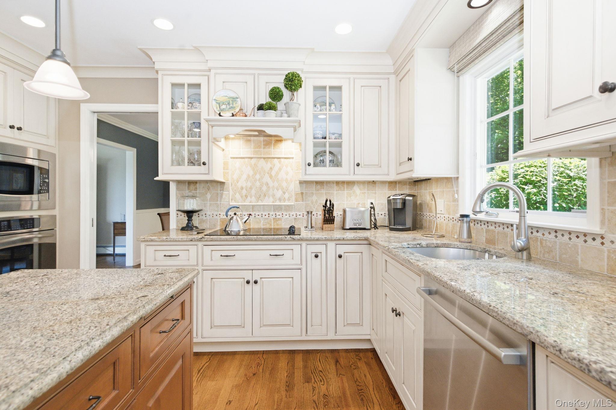 32 Bedell Road Katonah, NY 10536 - Photo 14 of 49 A mantel-style range hood with under-cabinet task lighting crowns the cooking wall.