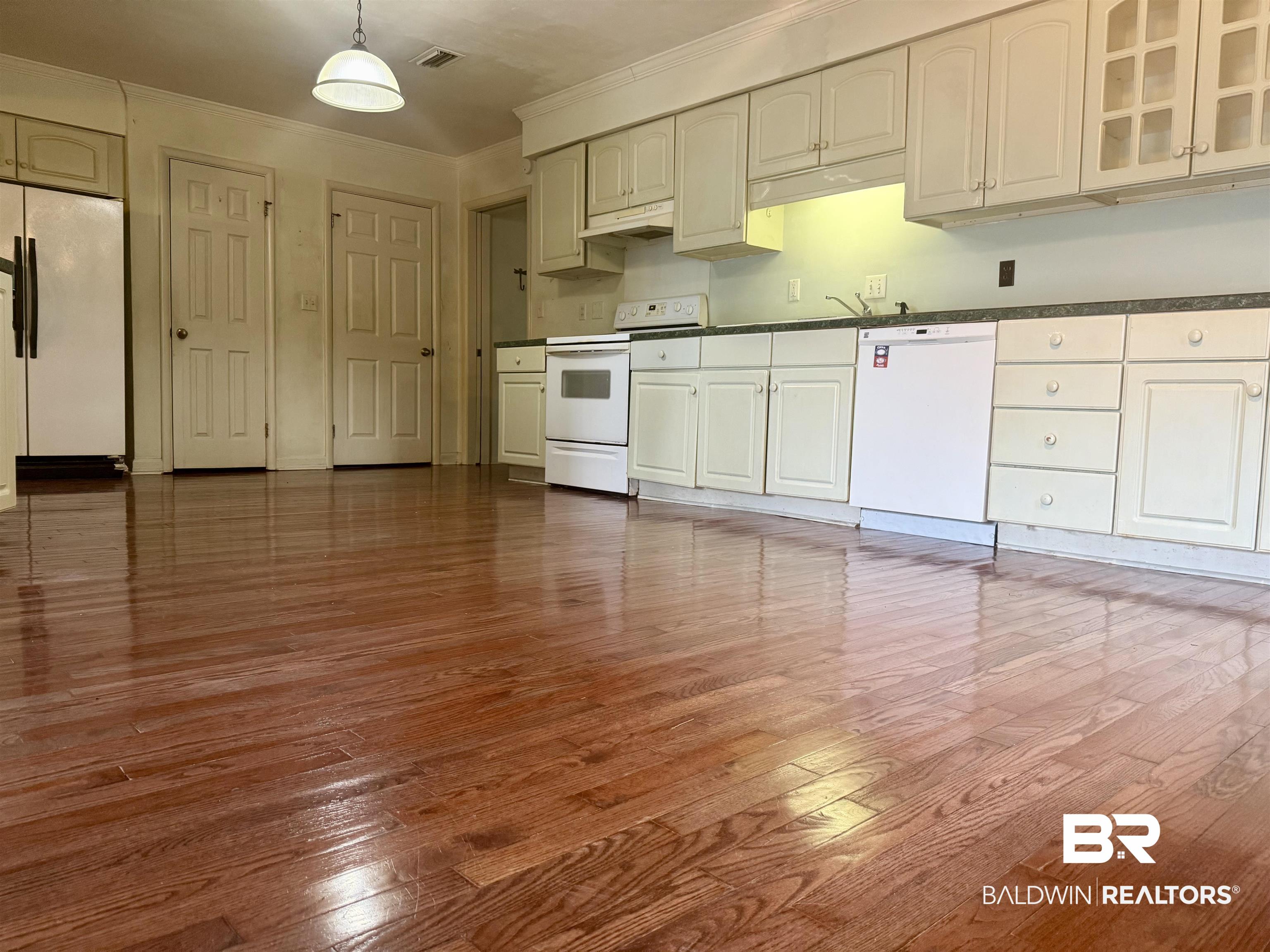 1412 Poplar Avenue Brewton, AL 36426 - Photo 9 of 32 Kitchen featuring white appliances, ornamental molding, dark countertops, dark wood-style flooring, and glass insert cabinets