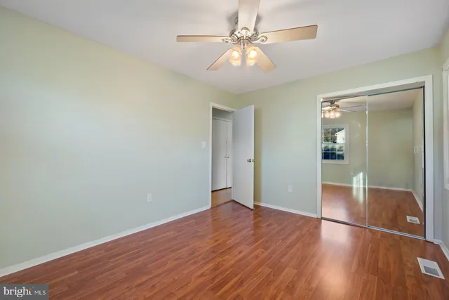 an empty room with wooden floor and mirror