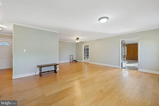 a view of an empty room with window and wooden floor