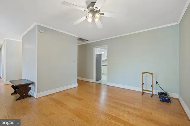 a view of an empty room with a ceiling fan and a window