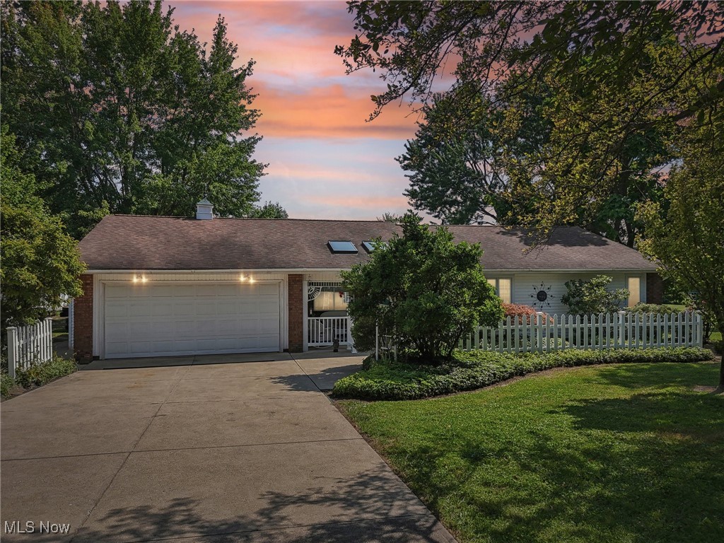 Single story home with a garage and a yard