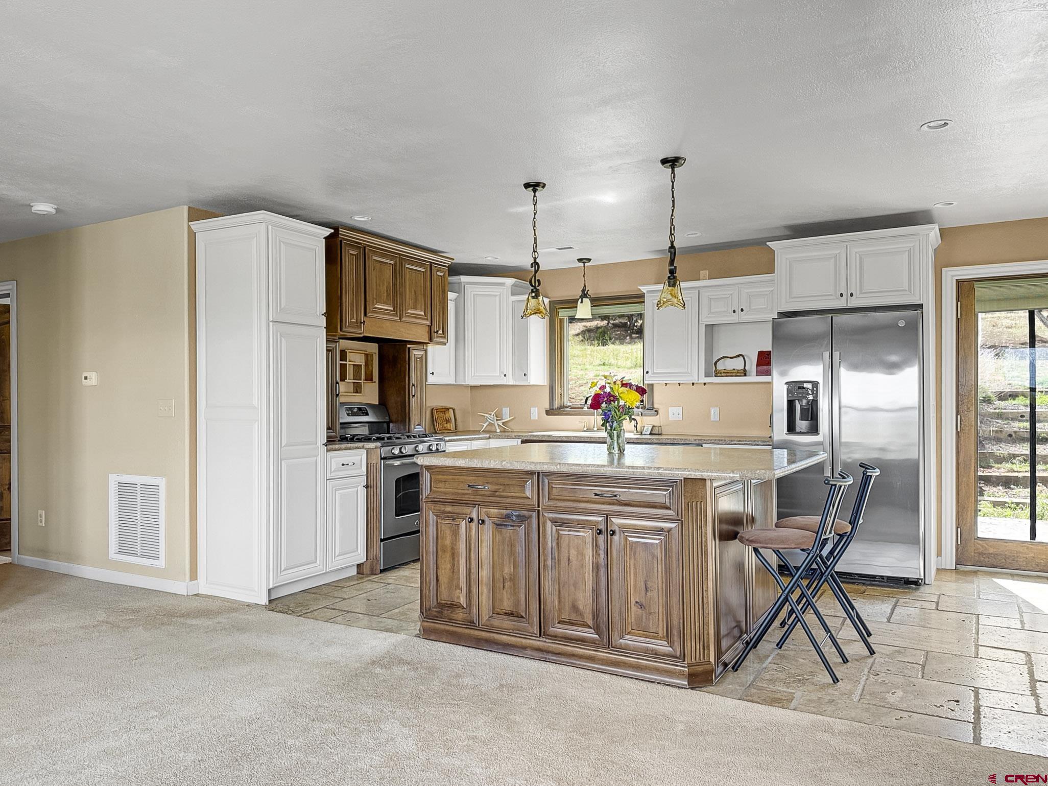 32310 B50 Road Crawford, CO 81415 - Photo 9 of 45 a kitchen with stainless steel appliances a sink a stove a refrigerator cabinets and dining table