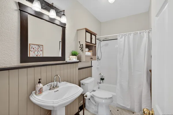 a bathroom with a sink a toilet and shower curtain