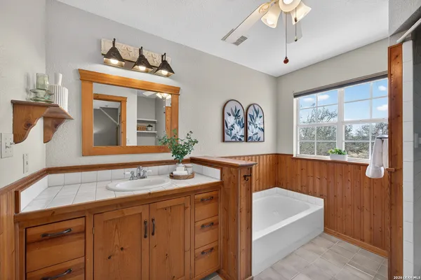 a bathroom with a sink a bathtub and a mirror