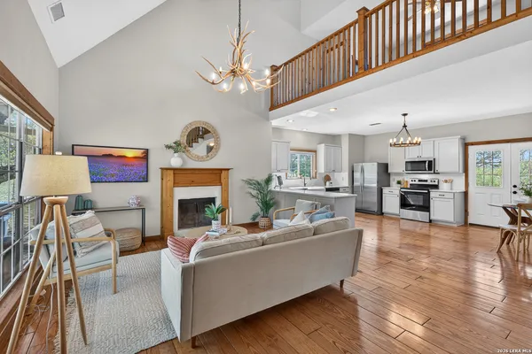a living room with furniture a fireplace and a chandelier