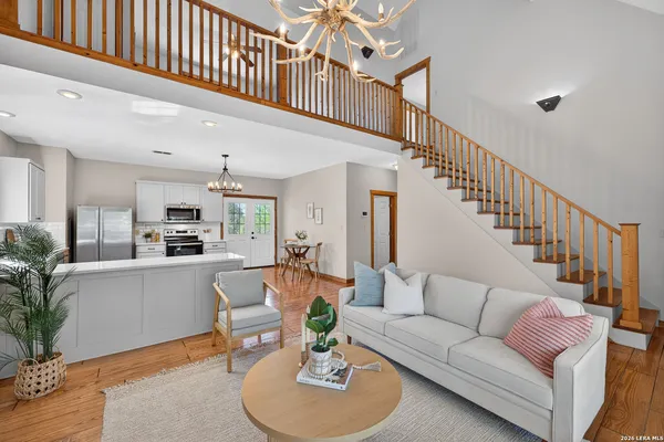 a living room with furniture kitchen view and a potted plant
