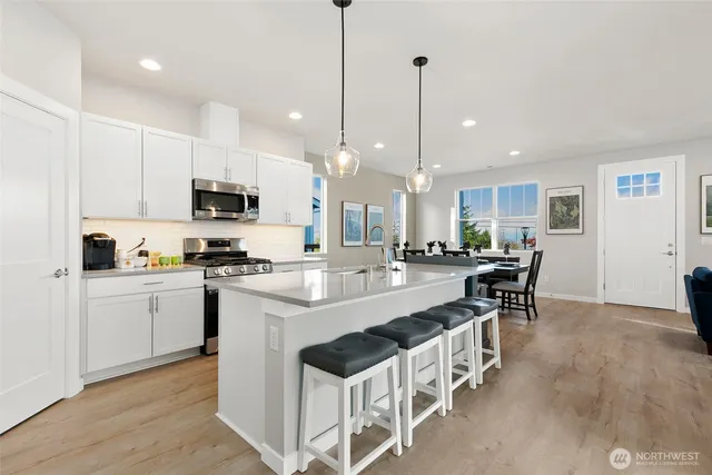 a large kitchen with kitchen island a dining table and chairs