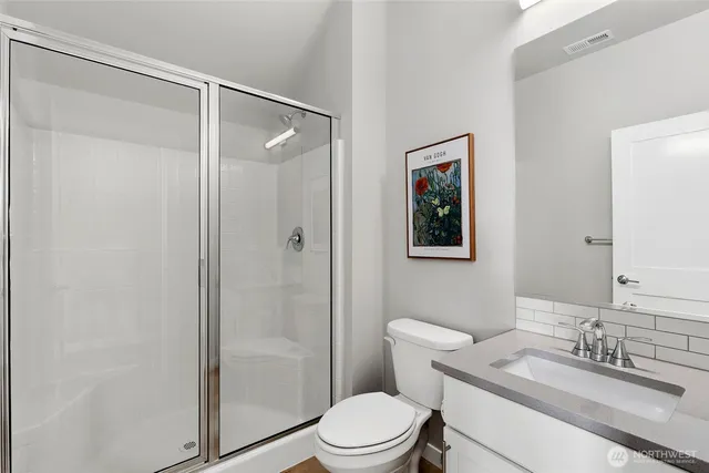 a bathroom with a granite countertop toilet sink and shower