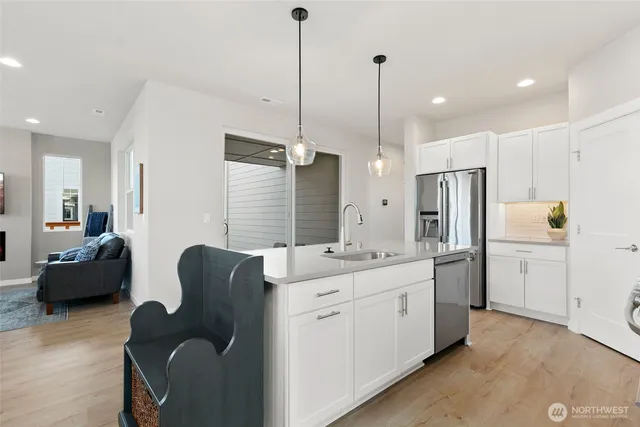 a large white kitchen with a refrigerator