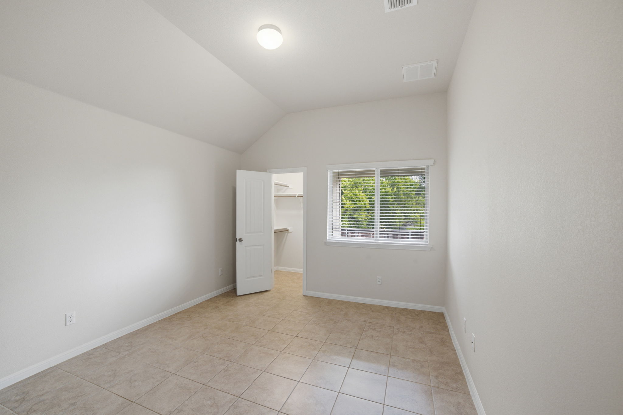 514 Nautical Loop Kyle, TX 78640 - Photo 21 of 24 An airy bedroom with vaulted ceilings and a practical walk-in closet for ample storage.