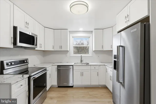 a kitchen with stainless steel appliances granite countertop a refrigerator sink and microwave
