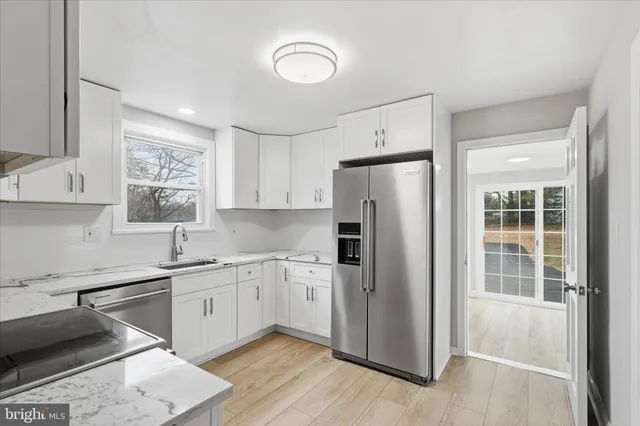 a kitchen with a refrigerator sink and cabinets