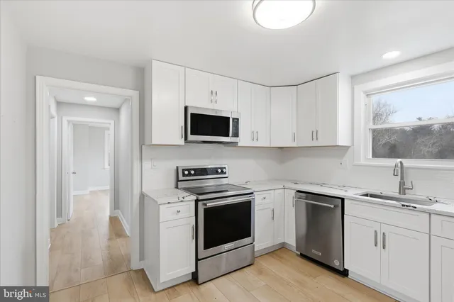 a kitchen with white cabinets and white appliances
