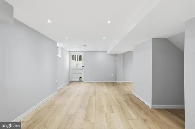 a view of a big room with wooden floor and windows