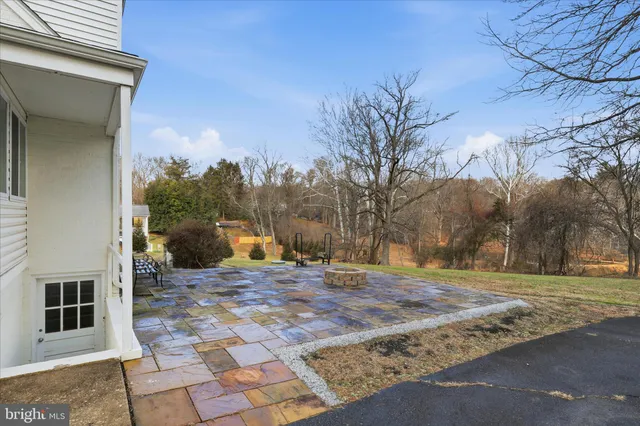 a view of a house with a big yard and large trees