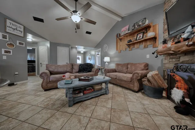 a living room with furniture a air conditioner vent and a flat screen tv