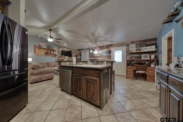 a kitchen with stainless steel appliances granite countertop a stove top oven a sink and a refrigerator