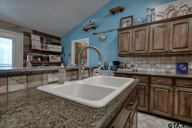 a kitchen with stainless steel appliances granite countertop a sink a stove and cabinets
