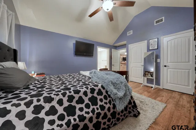 a bedroom with a large bed and a flat tv screen