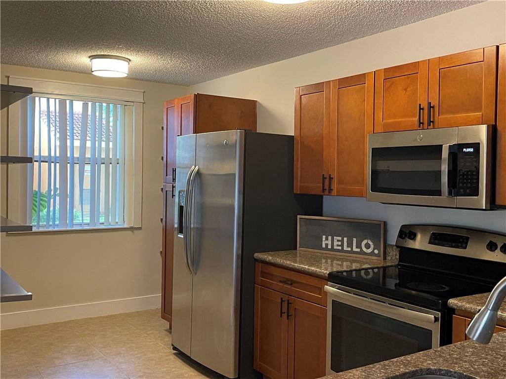 a kitchen with stainless steel appliances granite countertop a refrigerator and a microwave
