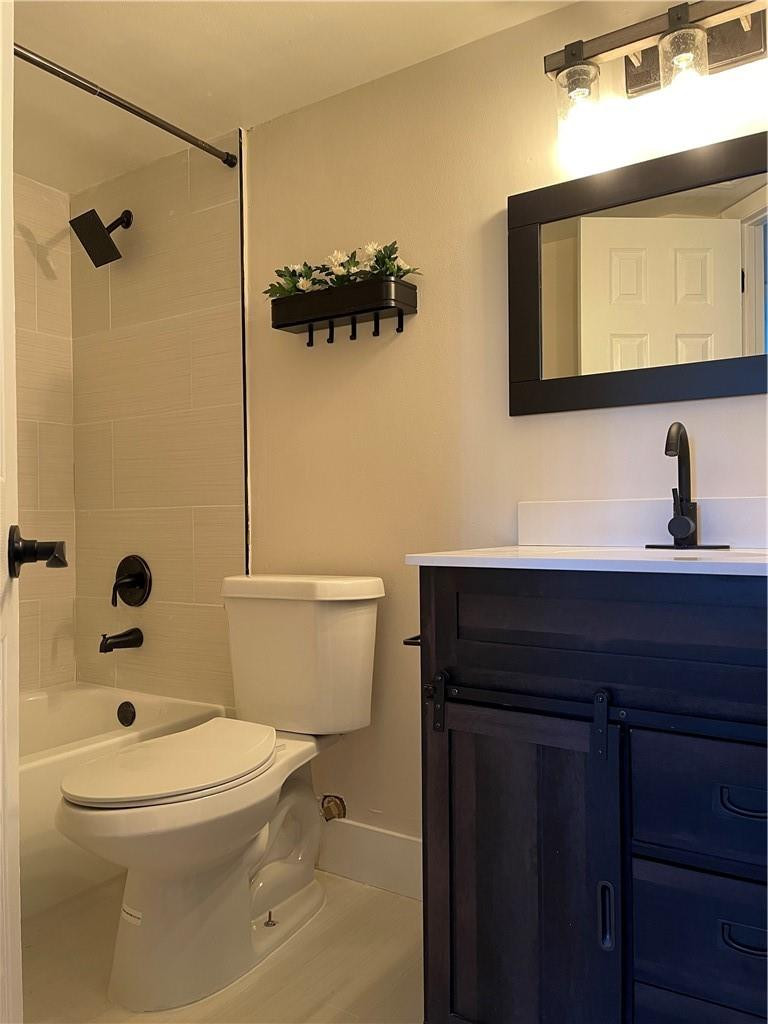 8801 Wiles Road, Unit 108 Coral Springs, FL 33067 - Photo 14 of 22 a bathroom with a toilet a sink and mirror