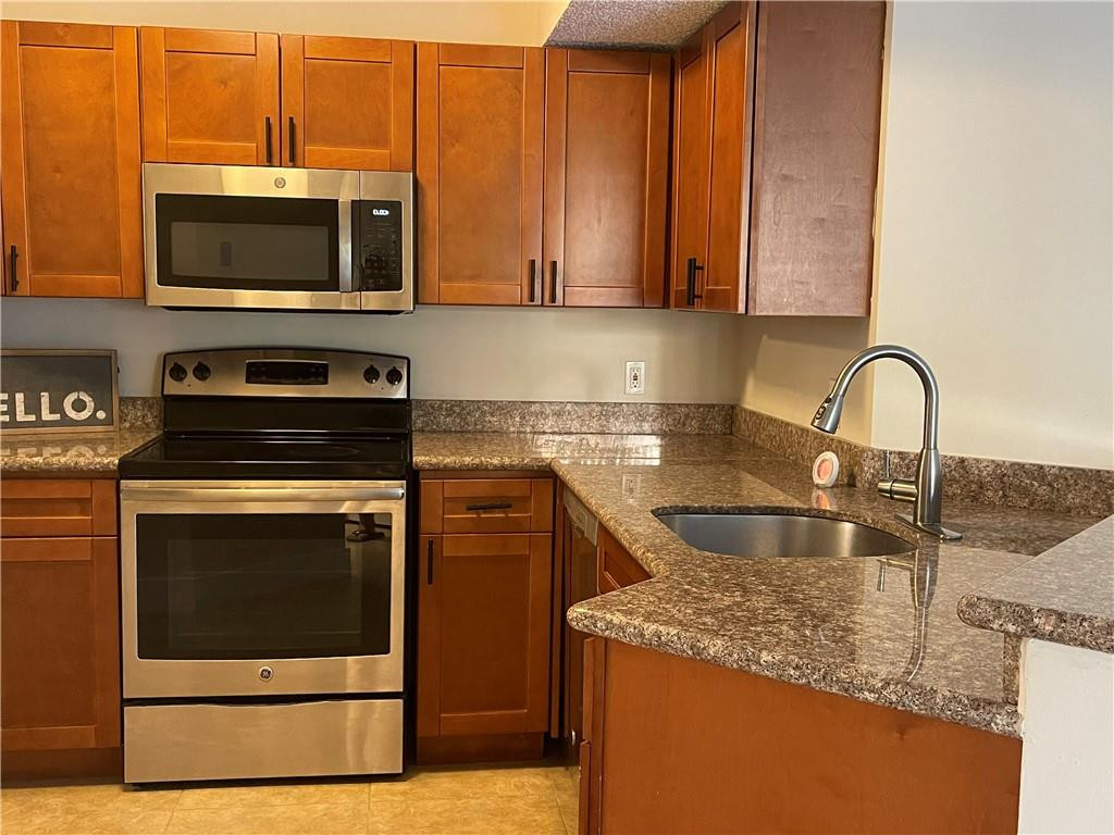 8801 Wiles Road, Unit 108 Coral Springs, FL 33067 - Photo 2 of 22 a kitchen with granite countertop a stove and a sink