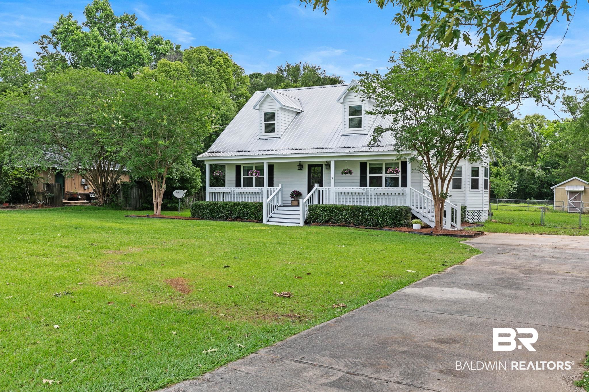 22810 High Ridge Road Fairhope, AL 36532 - Photo 8 of 78 White siding residence featuring a metal roof, front porch with white railing, and decorative dormer windows