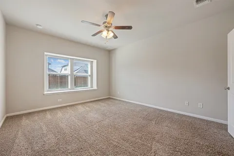 a view of an empty room with chandelier fan