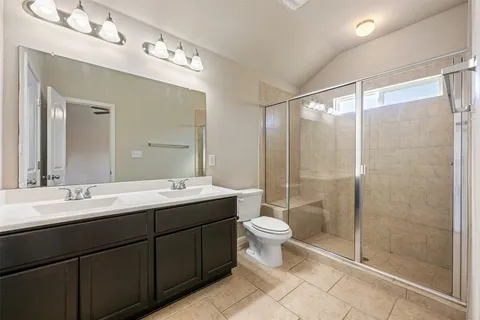 a bathroom with a double vanity sink mirror and toilet