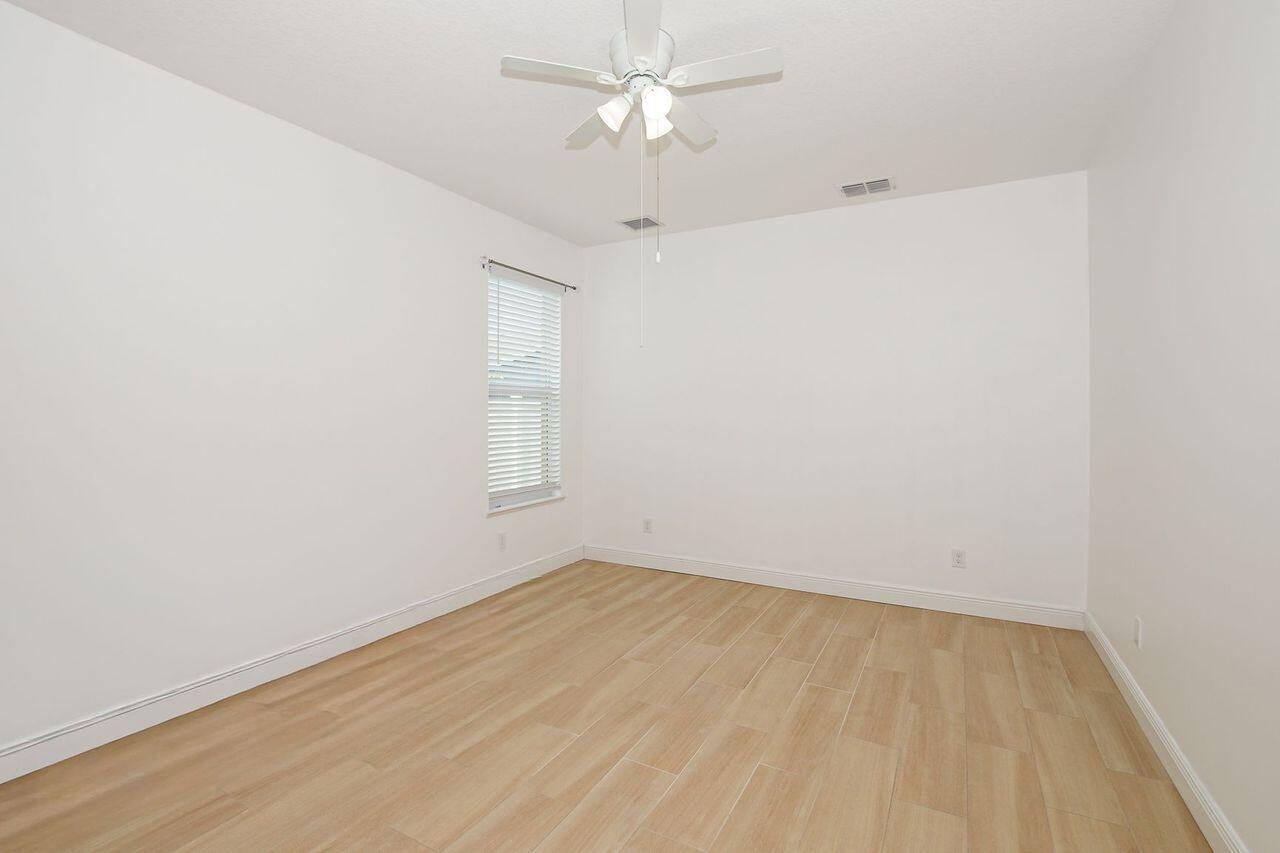 341 Southwest Kestor Drive, Unit 341 Port St. Lucie, FL 34953 - Photo 6 of 19 an empty room with a window and a ceiling fan