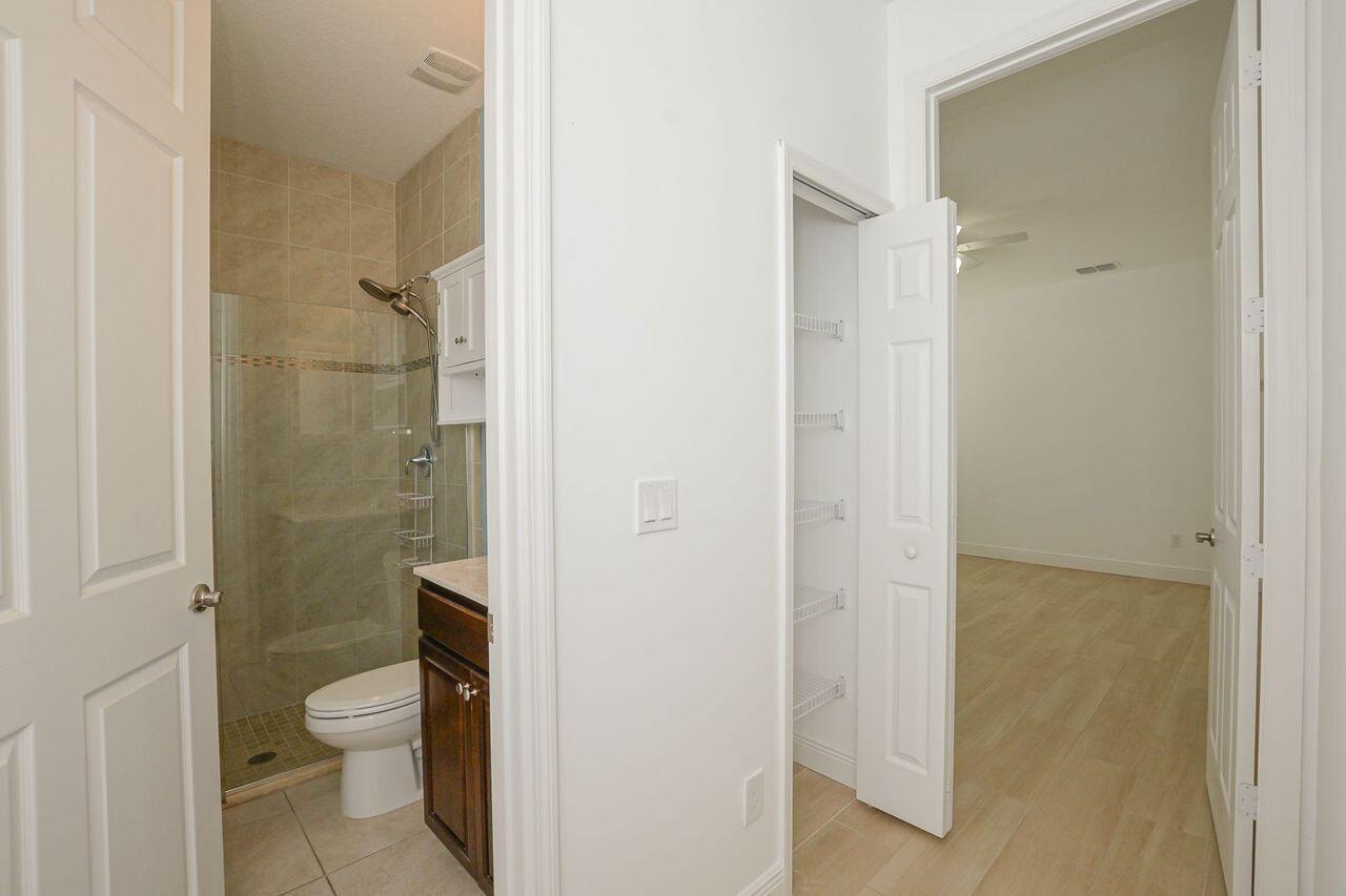 341 Southwest Kestor Drive, Unit 341 Port St. Lucie, FL 34953 - Photo 9 of 19 a bathroom with a granite countertop toilet a sink and shower