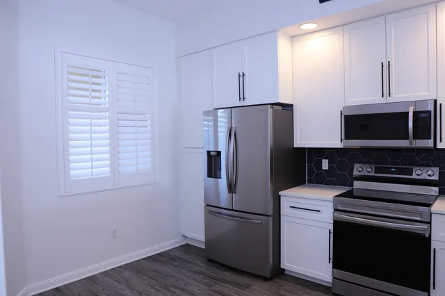 a kitchen with stainless steel appliances a refrigerator microwave and sink