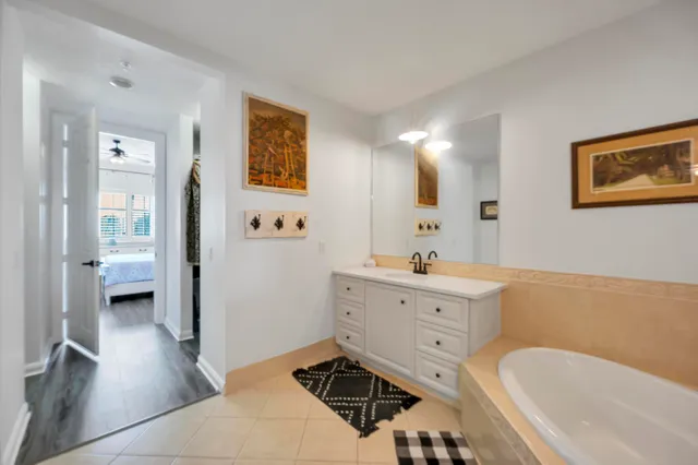 a spacious bathroom with a tub sink and mirror