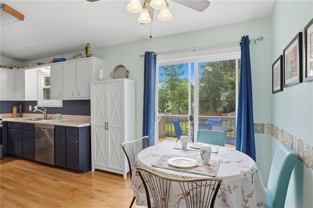 338 Arbour Way Suwanee, GA 30024 - Photo 10 of 32 a kitchen with stainless steel appliances granite countertop a stove a refrigerator a white table and chairs with wooden floor