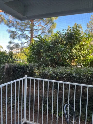 a view of a house with a big yard plants and large trees