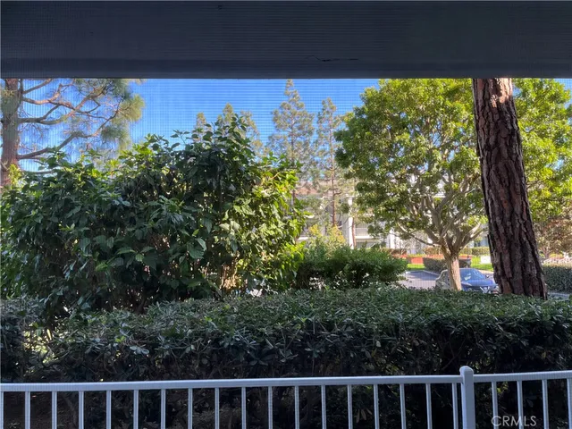 a front view of a house with a garden and trees