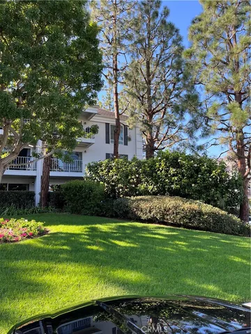 a view of a house with a big yard and large trees