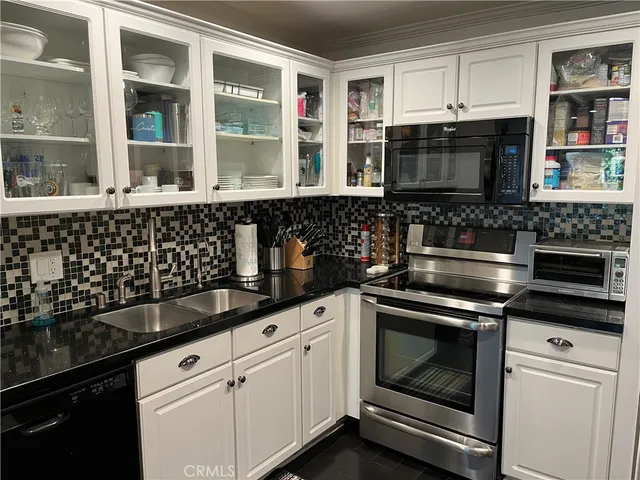 a kitchen with granite countertop a stove and a microwave