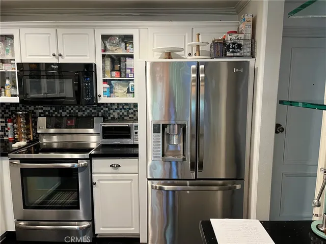 a kitchen with stainless steel appliances a refrigerator a stove and a cabinets