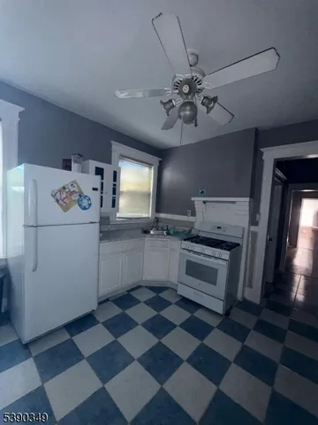 a kitchen with a checkered floor and white cabinets