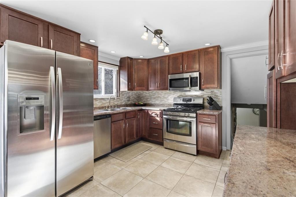 301 Amity Road Glenshaw, PA 15116 - Photo 6 of 30 a kitchen with granite countertop stainless steel appliances and a refrigerator